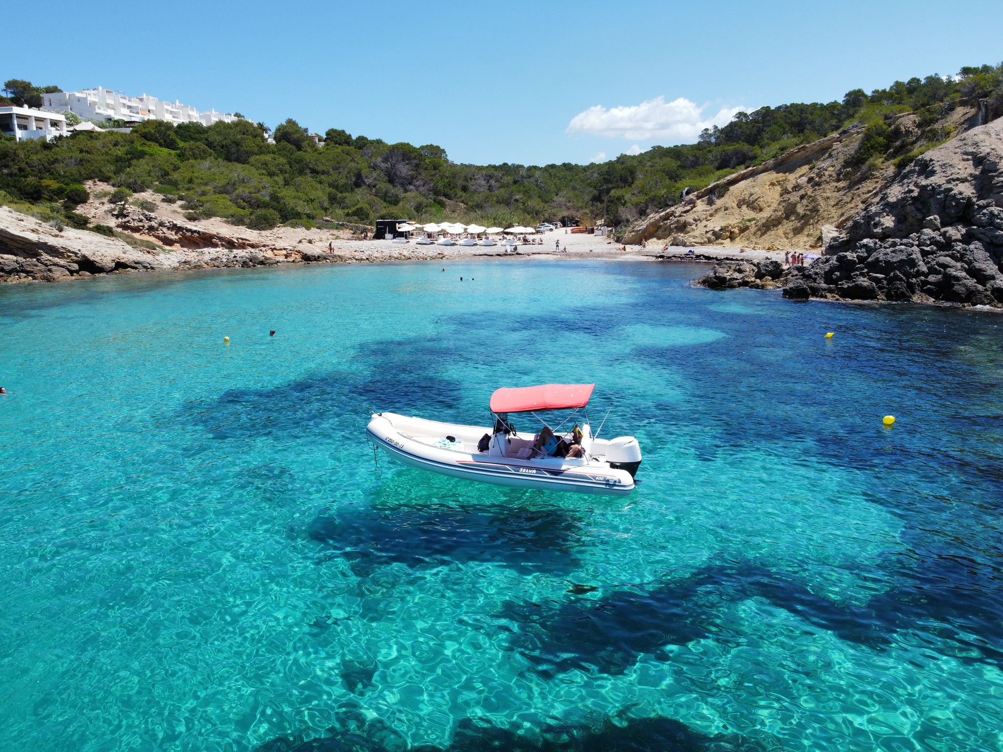 Barco fondeado frente a una cala de Ibiza